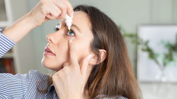 Woman applying eye drops